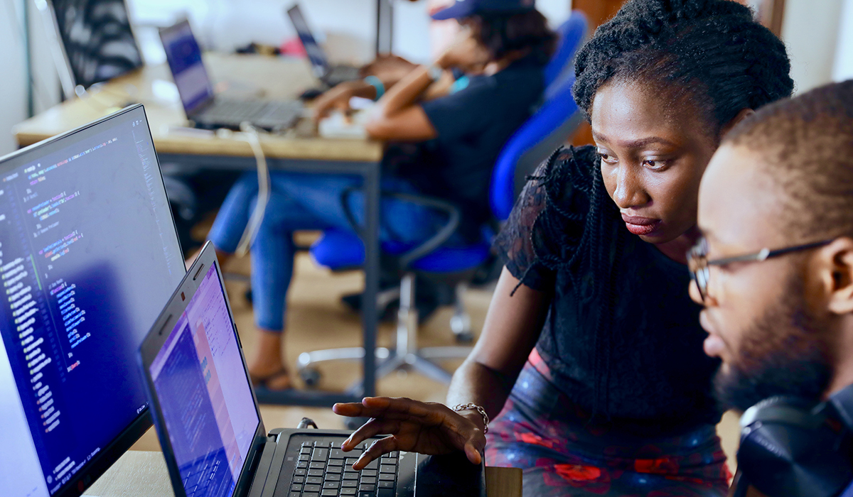 two students working on a laptop and desktop together