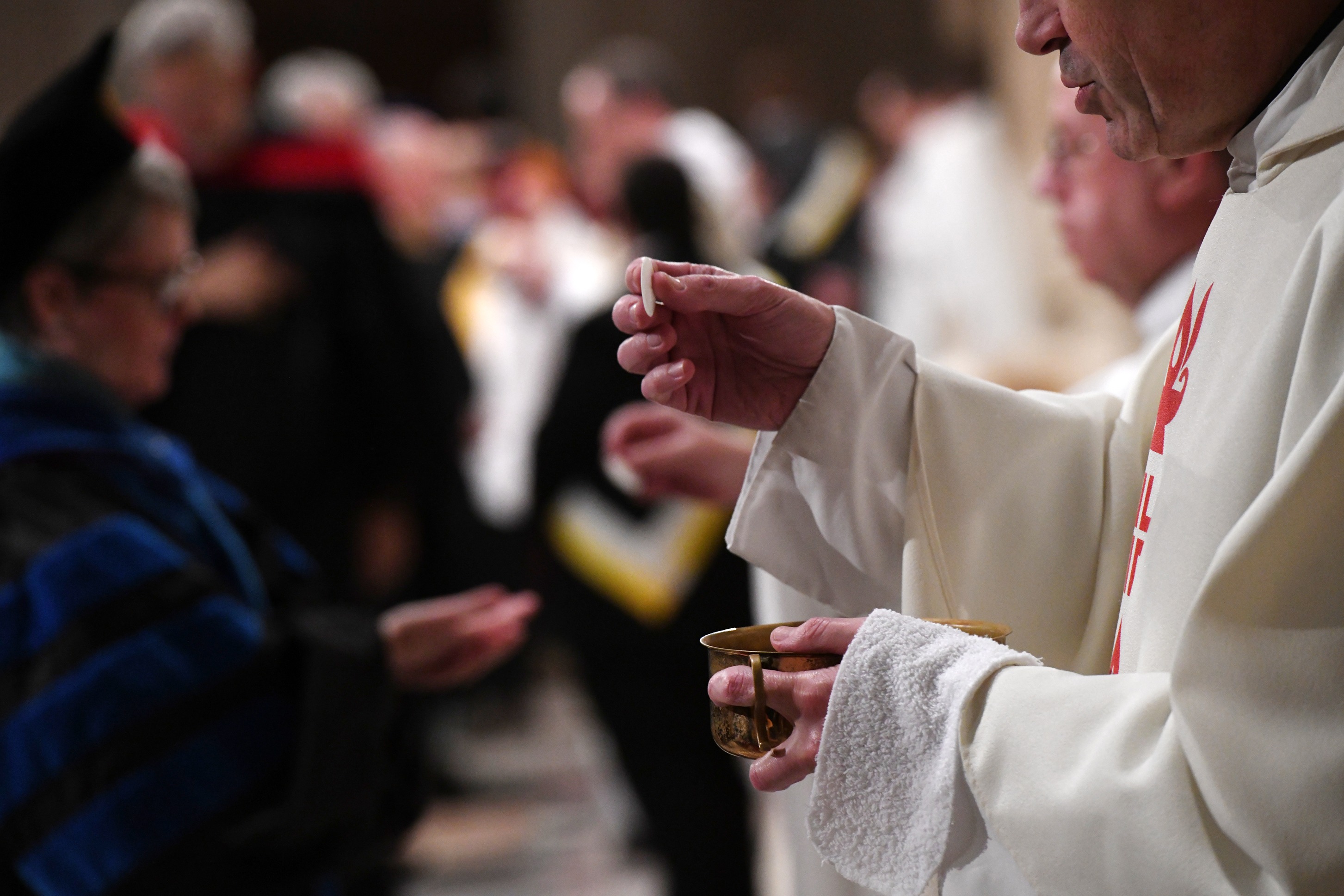 Attendees receive communion at the Aquinas Mass.