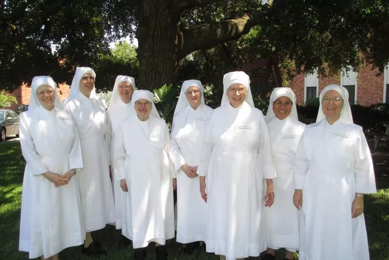 Sister Carolyn Martin (left), a vocations coordinator for The Little Sisters of the Poor, poses with her fellow sisters, all smiling gleefully. 