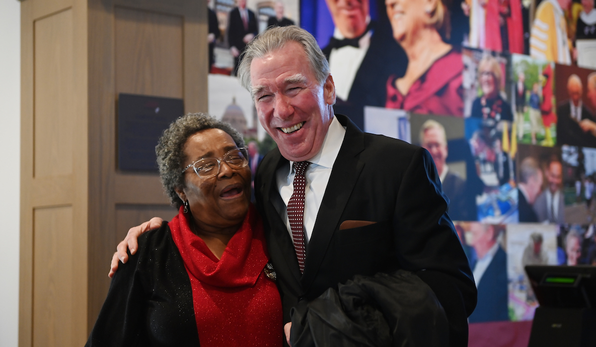 Willie Joyner, University food services employee, shares a hug with former University President John Garvey.