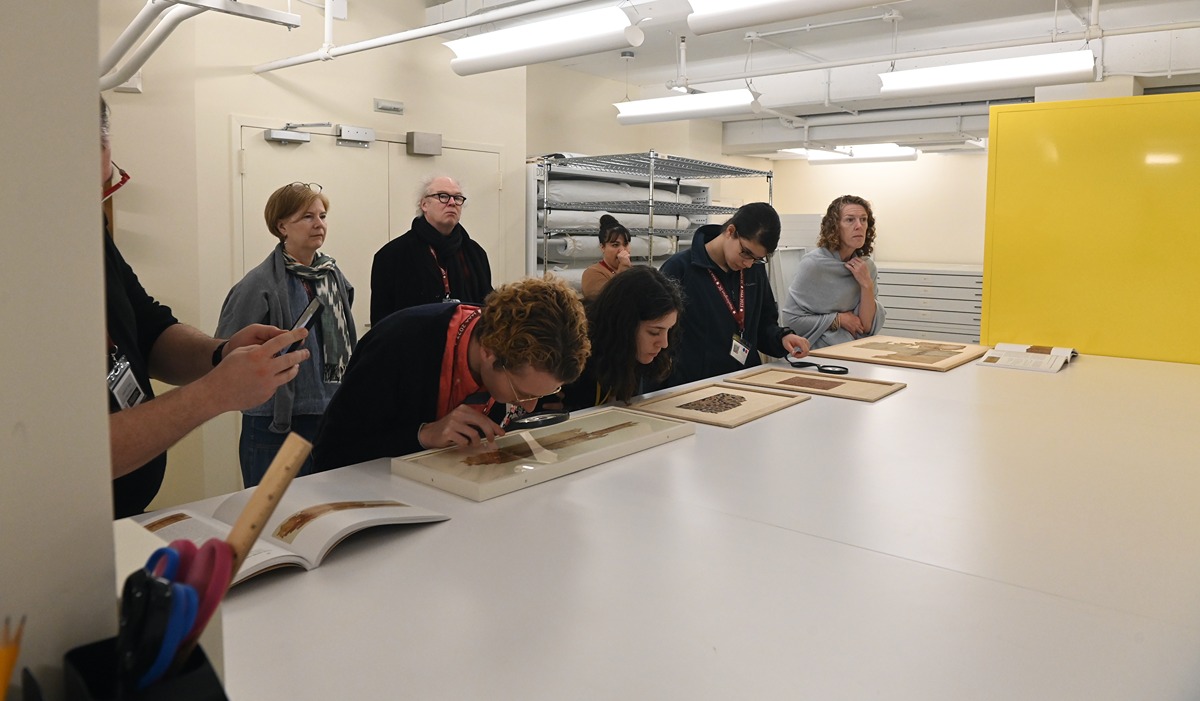 Students examine items on a table