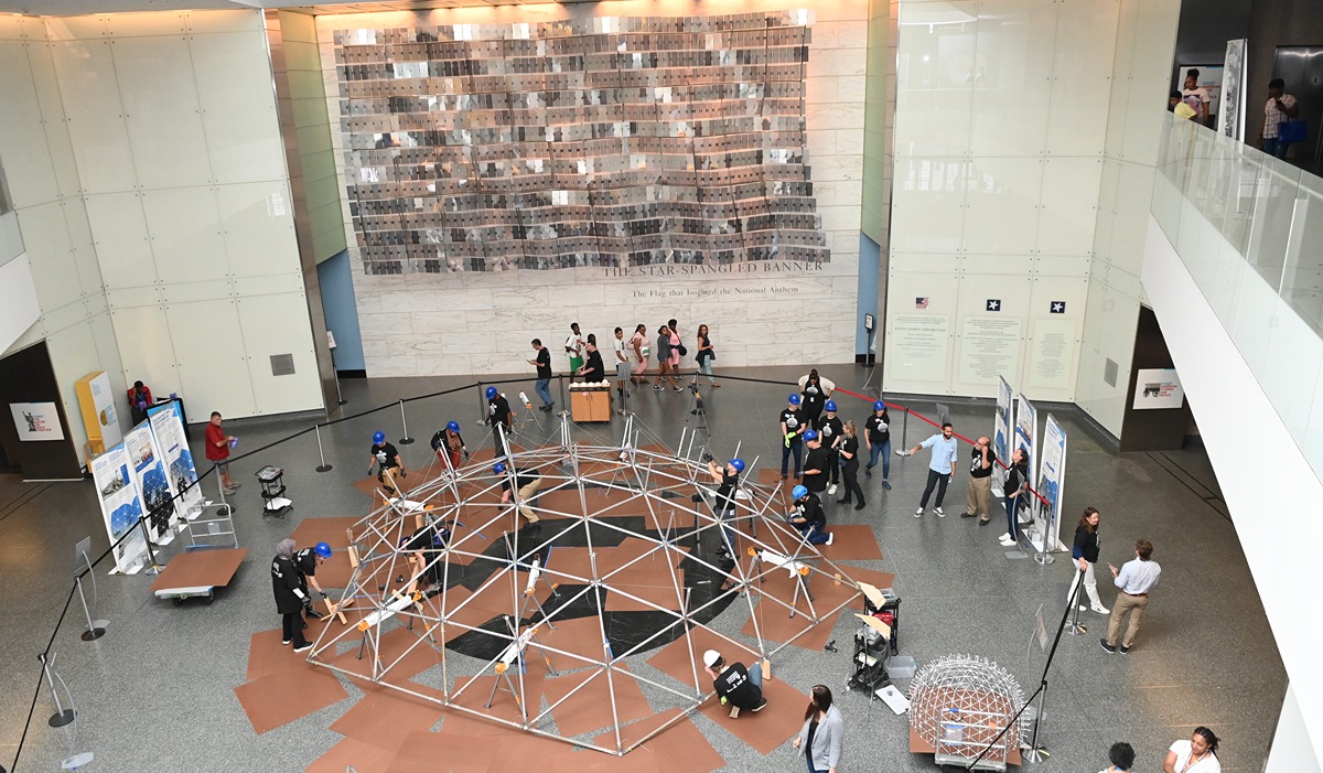 Students, faculty, and museum staff building a historic dome