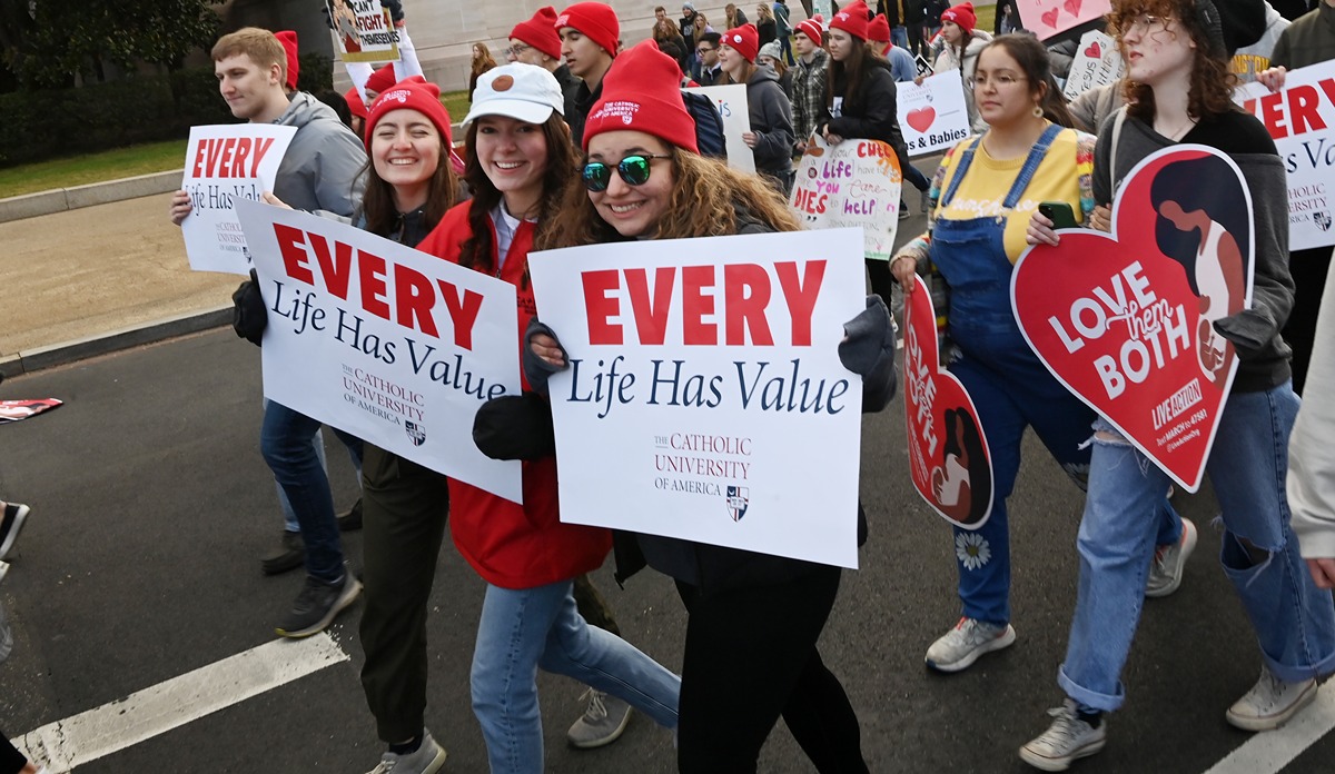 students holding signs at the march for life