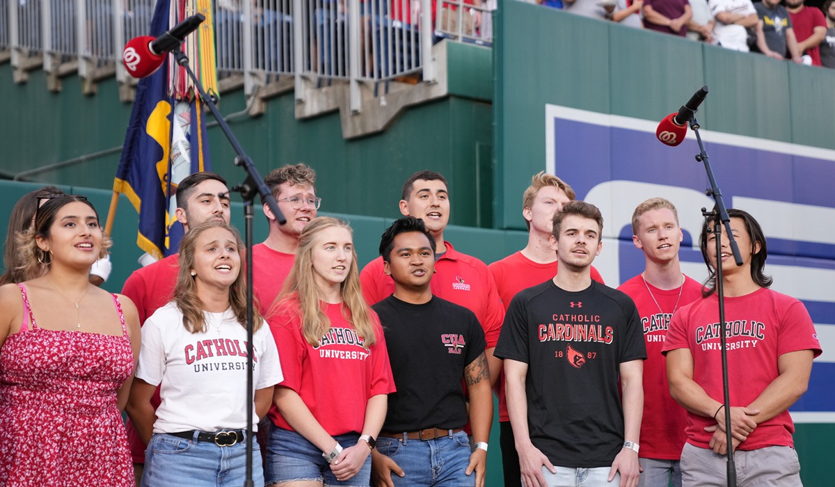 Catholic university students singing the national anthem at the nationals game