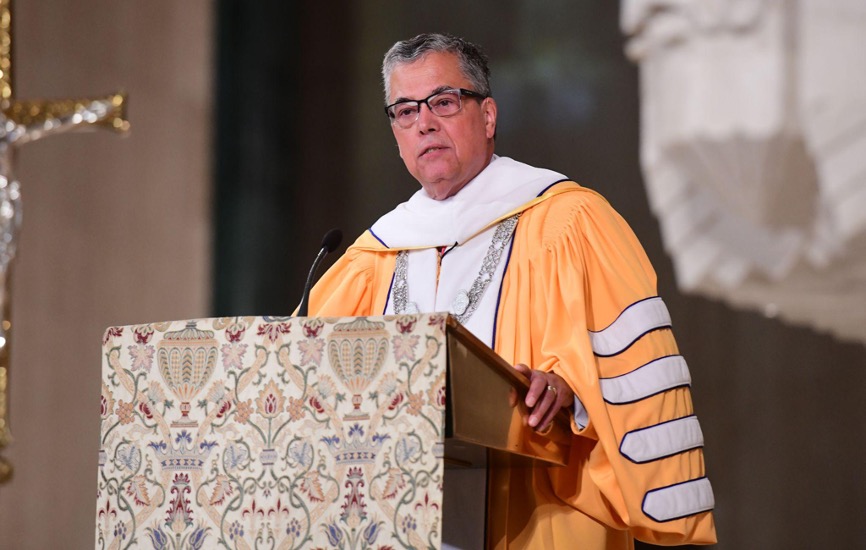 President Kilpatrick in a yellow robe speaking in the basilica