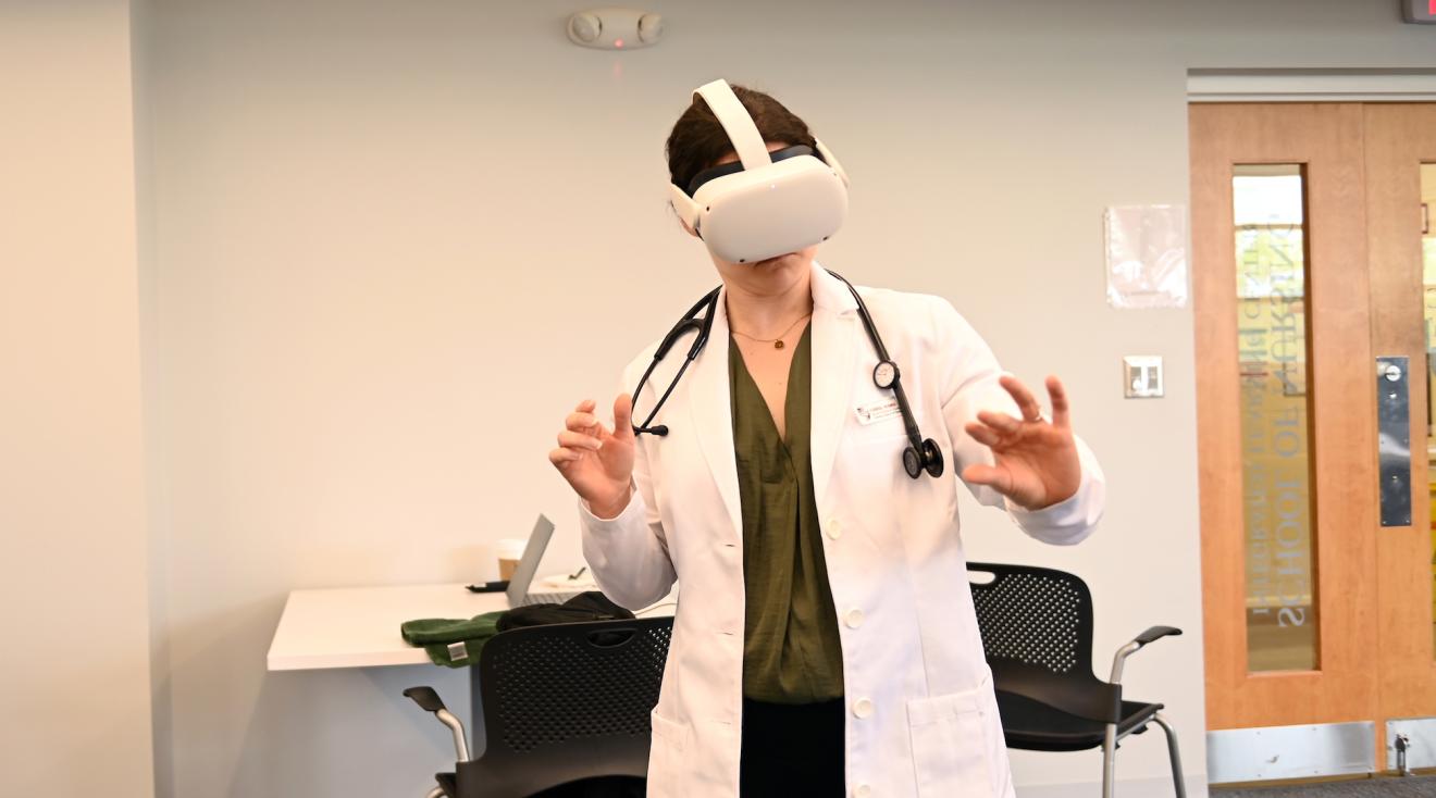 A nursing student uses a headset during a demo for an immersive simulation of a lumbar puncture procedure.