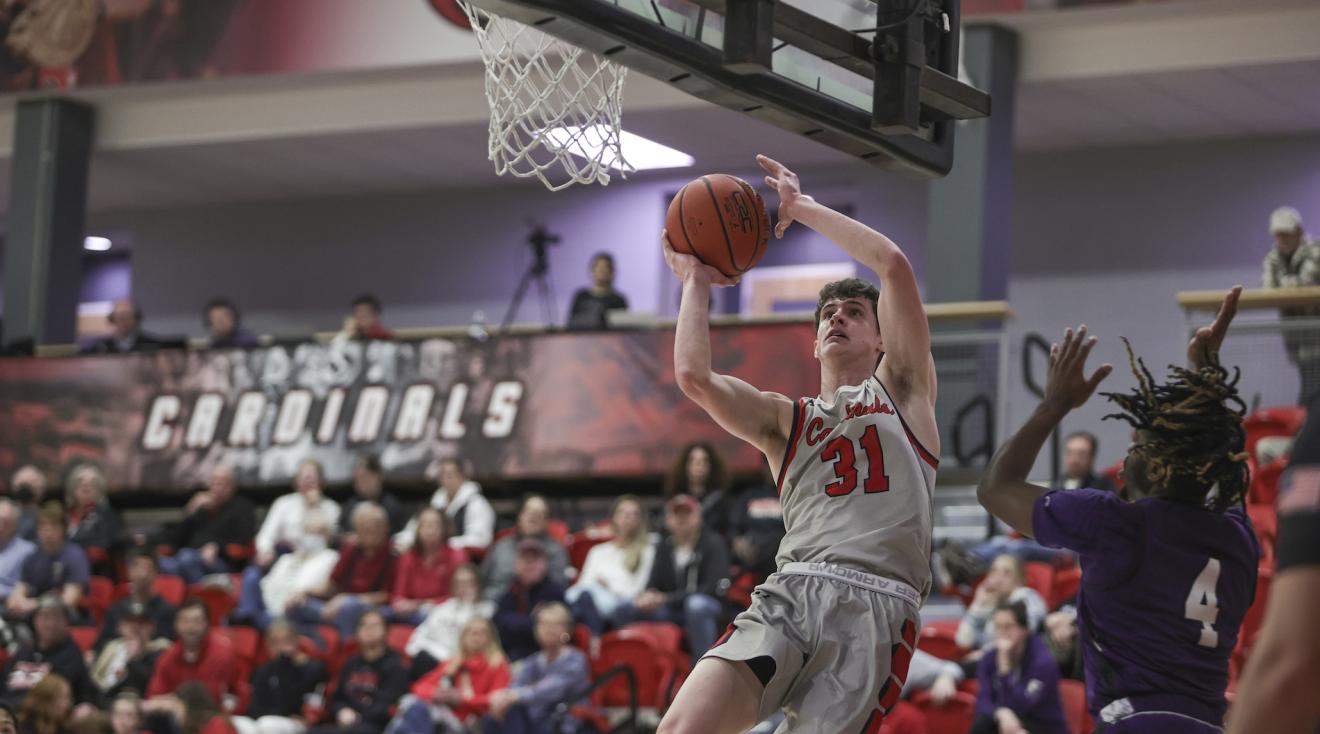 men's basketball team member jumping to take a shot