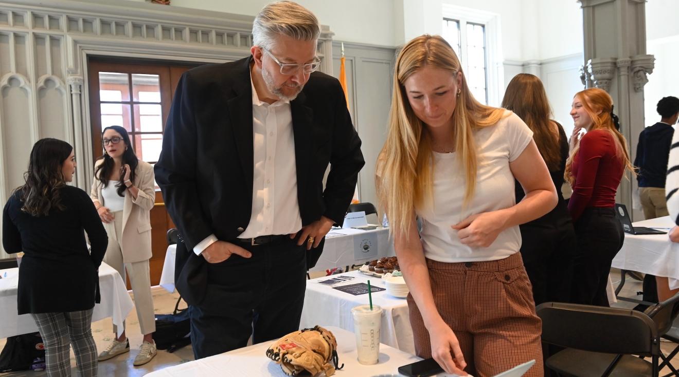 business student and professor looking at a project together